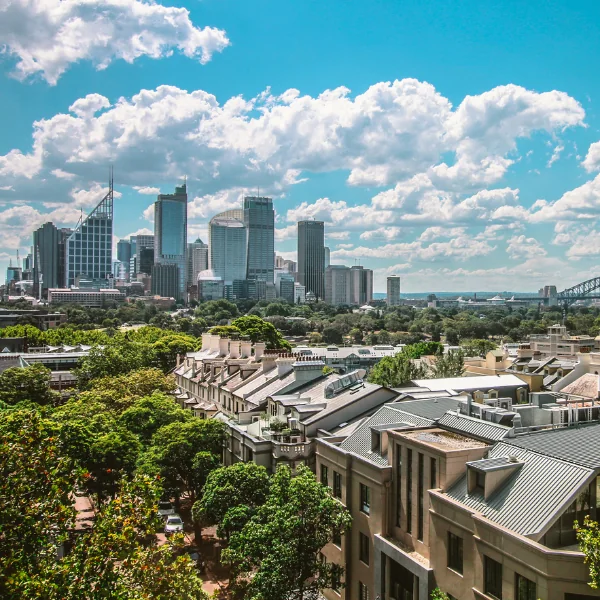 City skyline with tall buildings and green trees in the foreground